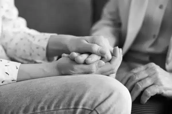 Loving young woman holding her senior mother's hand